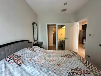 Cozy bedroom with modern decor and ensuite bathroom in a stylish apartment.