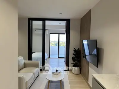 Modern living room with sleek design and natural light, featuring a cozy sofa and wall-mounted TV.