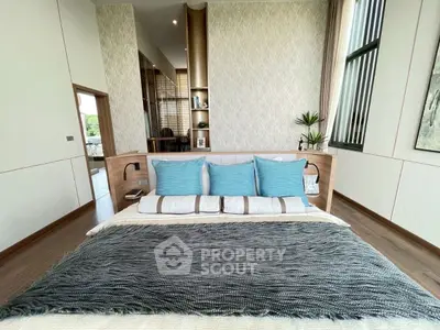 Luxurious bedroom with modern decor and large windows offering natural light