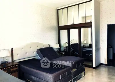 Spacious bedroom with adjustable beds and mirrored wardrobe in modern apartment.