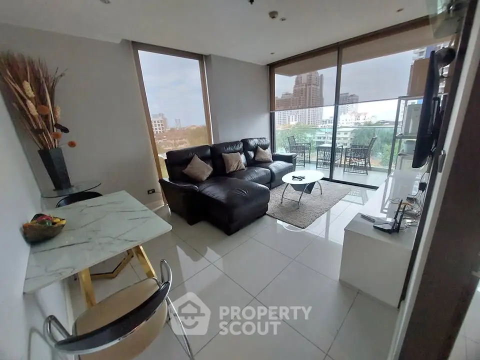 Modern living room with city view, sleek furniture, and natural light.