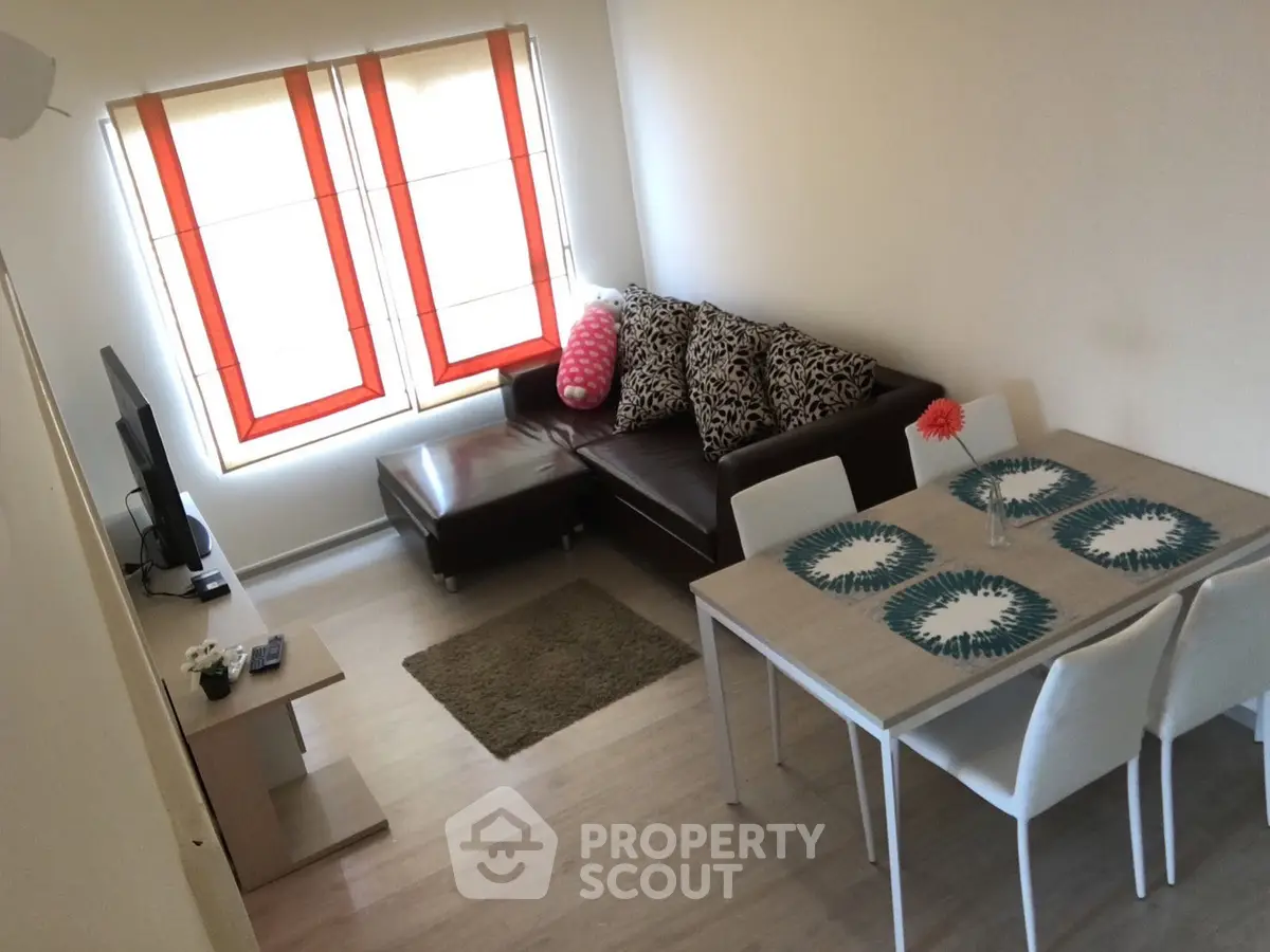 Cozy living room with modern decor and natural light, featuring a stylish sofa and dining area.