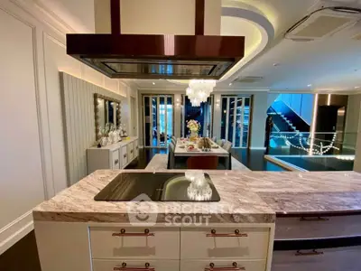 Luxurious modern kitchen with marble countertops and elegant lighting in a stylish open layout.