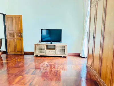 Spacious living room with wooden flooring and modern TV setup