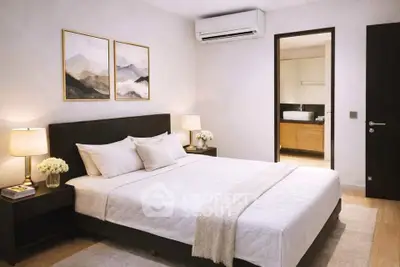 Elegant bedroom with modern decor and ensuite bathroom, featuring cozy lighting and stylish artwork.