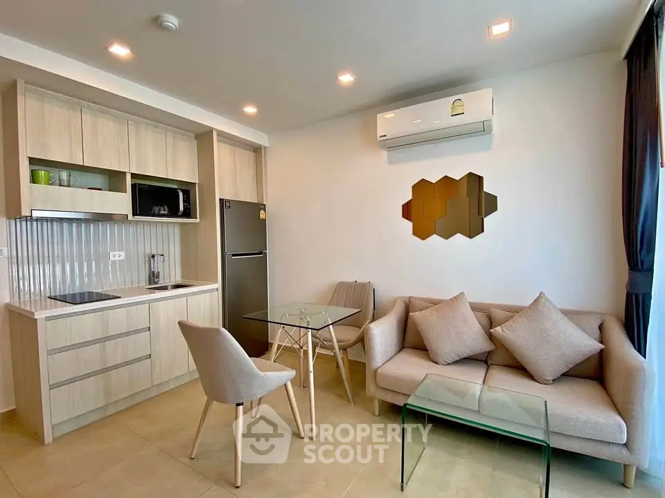 Modern open-layout kitchen and living area with stylish furniture and air conditioning.