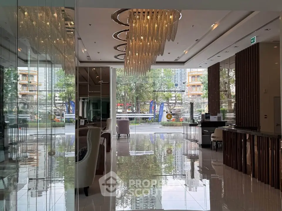 Luxurious lobby with modern chandelier and glass walls offering a stunning view of the cityscape.