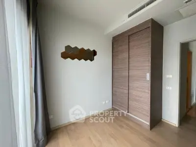 Modern bedroom with wooden wardrobe and stylish decor in a contemporary apartment.