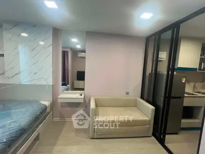 Modern studio apartment with cozy living area and sleek kitchen design.