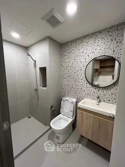 Modern bathroom with sleek shower and stylish vanity in contemporary apartment.