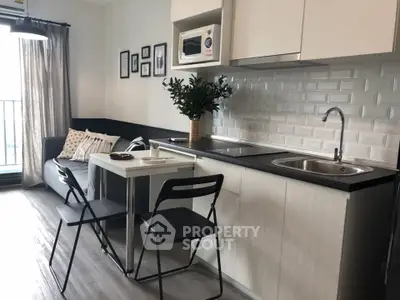 Modern kitchen with open layout and cozy dining area in stylish apartment.