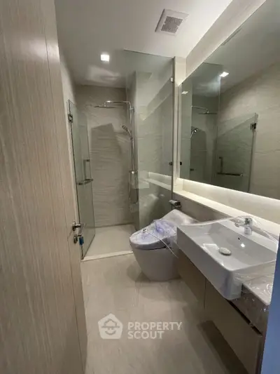 Modern bathroom with glass shower and sleek fixtures in contemporary apartment