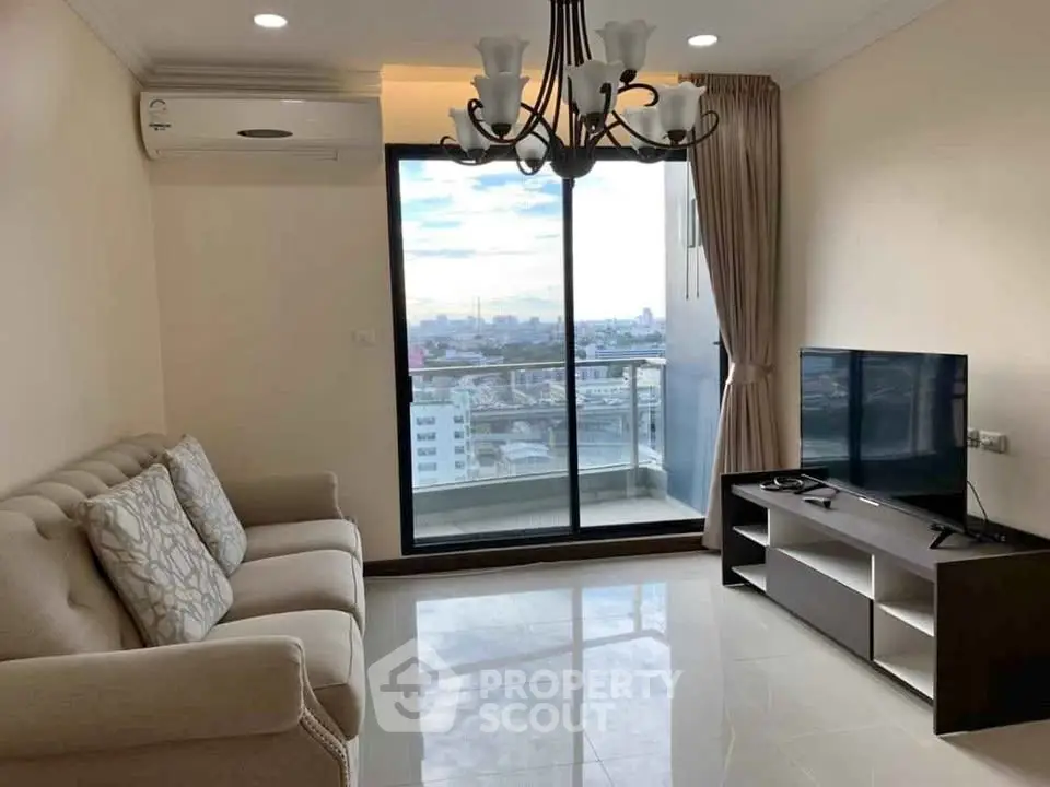 Modern living room with city view, featuring elegant chandelier and cozy sofa.