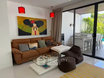 Stylish living room with modern decor and poolside view, featuring cozy seating and vibrant artwork.