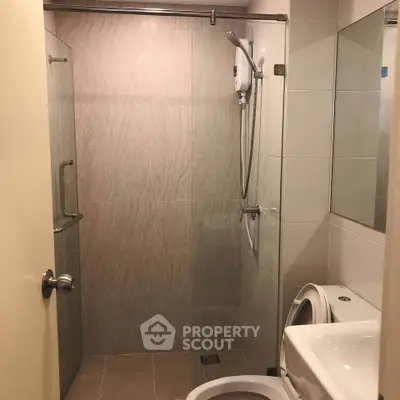 Modern bathroom with glass shower enclosure and sleek fixtures.