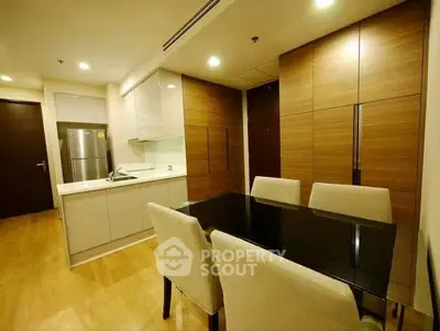 Modern kitchen with sleek dining area and wooden cabinetry in a stylish apartment.