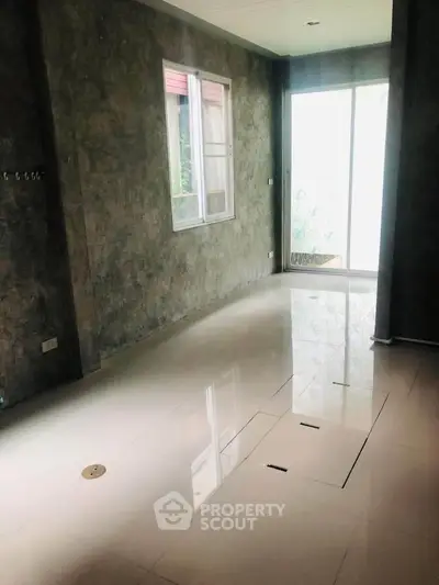 Spacious interior with glossy floors and large window, perfect for modern living.
