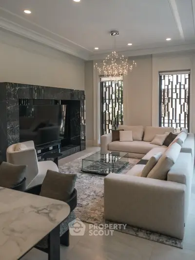 Luxurious modern living room with elegant marble fireplace and chic chandelier