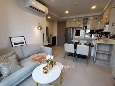 Modern open-layout living room and kitchen with stylish decor and contemporary furniture.