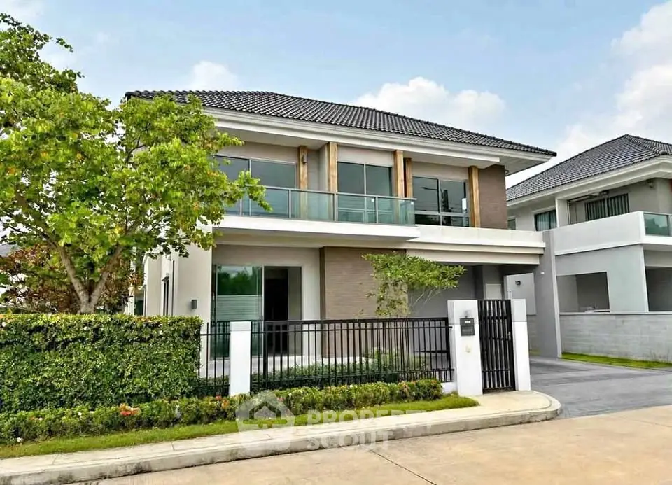 Modern two-story house with sleek design and lush greenery