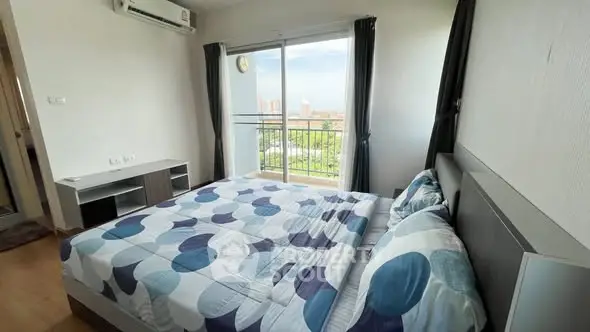 Spacious bedroom with balcony and city view in modern apartment