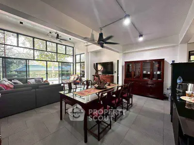 Spacious living and dining area with modern decor and large windows offering natural light.