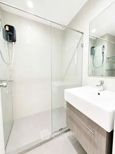 Modern bathroom with sleek shower and elegant sink in contemporary apartment.