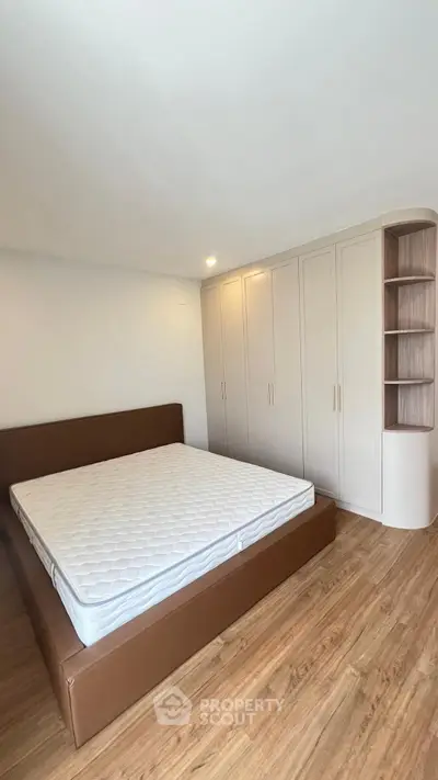 Spacious bedroom with modern design and ample storage in a luxury apartment.