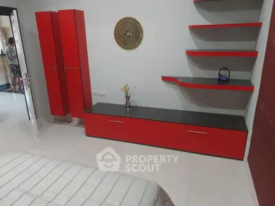 Modern bedroom with red furniture and decorative wall shelves