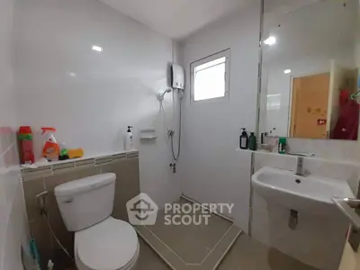 Modern bathroom with shower, toilet, and sink in a compact layout.
