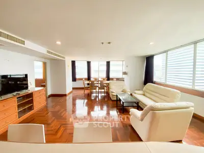 Spacious living room with elegant wooden flooring and modern furniture in a bright apartment.