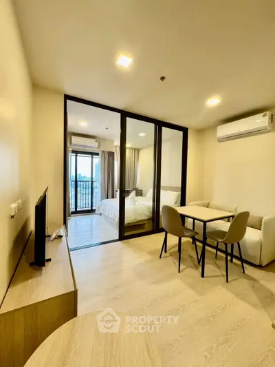 Modern open-plan living room with glass partition and cozy dining area