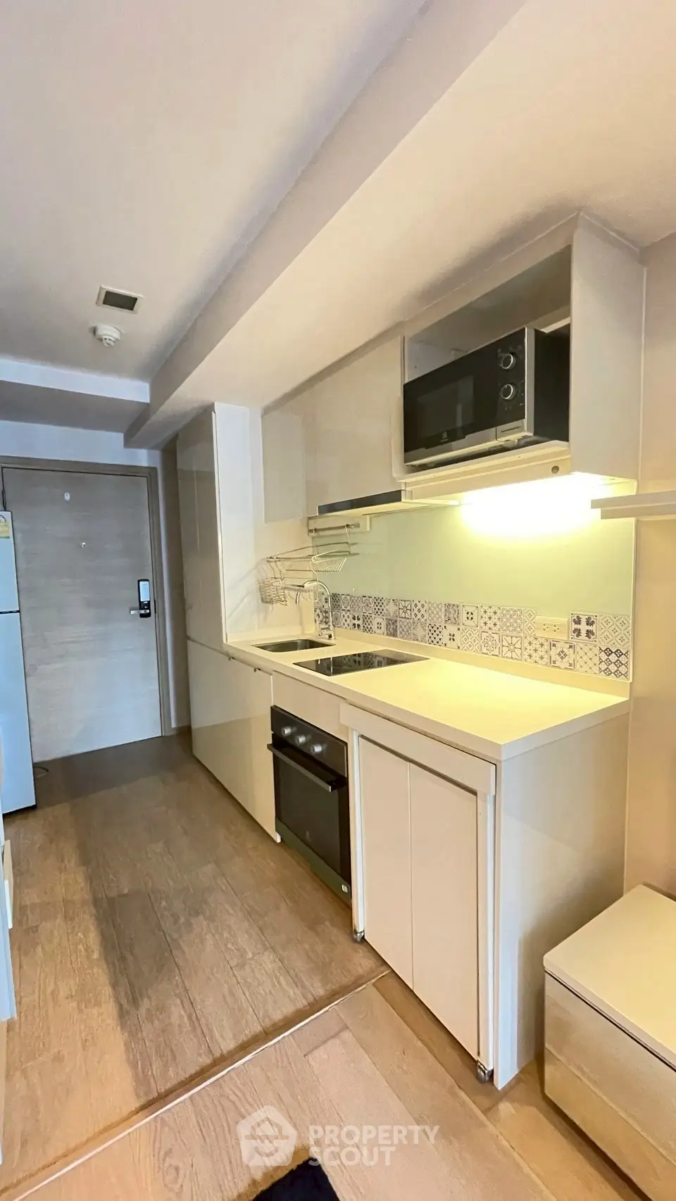 Modern kitchen with sleek appliances and stylish backsplash in a contemporary apartment.