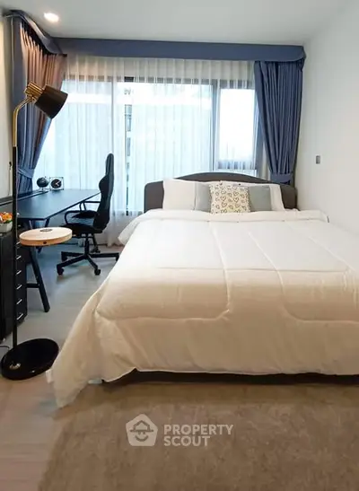 Modern bedroom with study area and large window, featuring elegant decor and natural light.
