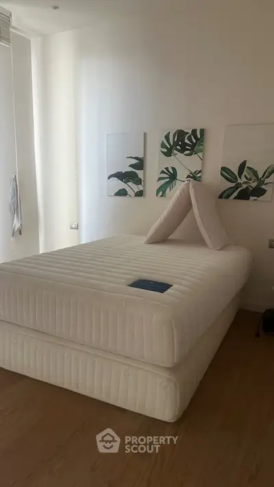 Modern bedroom with minimalist decor and stylish artwork on the wall.