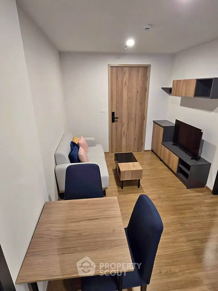 Modern living room with sleek furniture and wooden flooring in a cozy apartment setting.