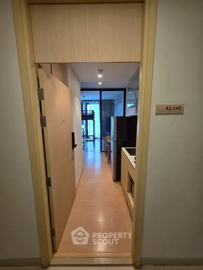 Modern apartment entrance with sleek kitchen and open layout