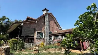 Charming rustic house with lush garden and unique architectural design.