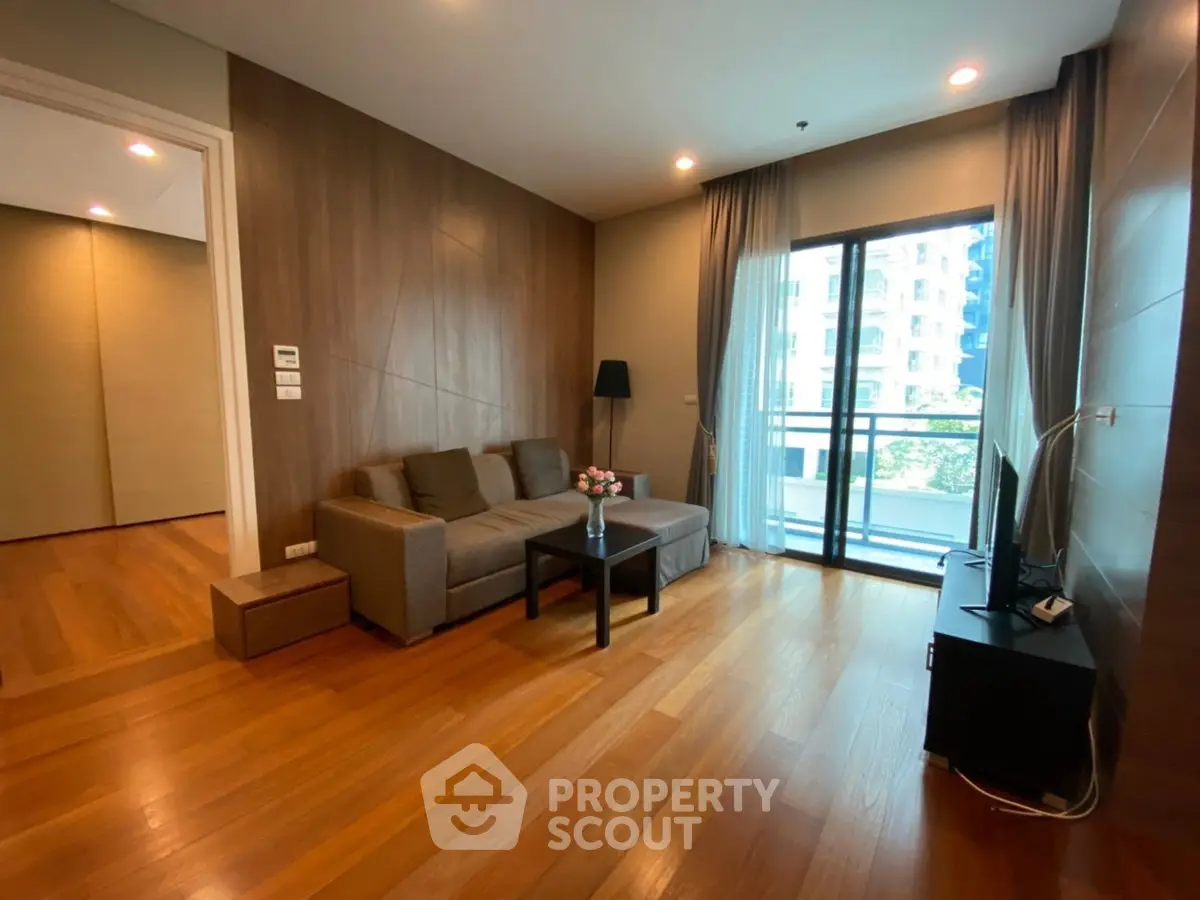 Spacious living room with modern decor and balcony view in luxury apartment.