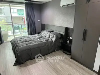 Modern bedroom with sleek design, featuring a cozy bed, large wardrobe, and balcony access for natural light.