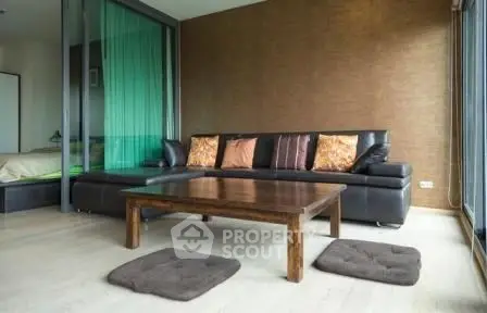 Modern living room with sleek black sofa and wooden coffee table in stylish apartment.