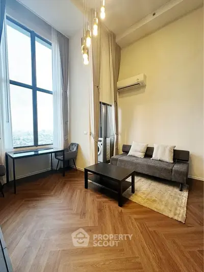 Modern living room with high ceilings, large windows, and stylish furniture in a city apartment.