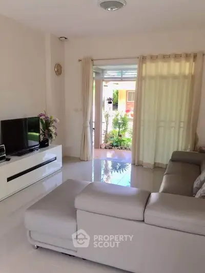 Modern living room with sleek furniture and garden view, perfect for relaxation and entertainment.
