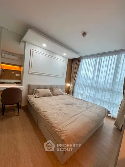 Modern bedroom with large window and stylish decor in a high-rise apartment.