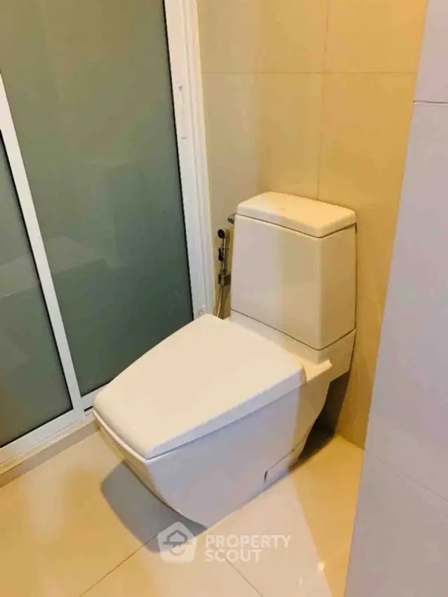 Modern bathroom with sleek toilet and glass shower door, perfect for contemporary living.