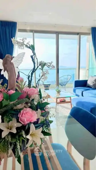 Luxurious living room with ocean view, elegant decor, and vibrant blue accents.