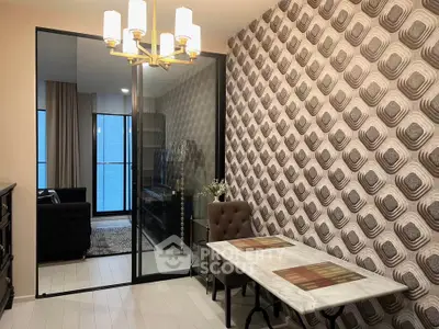 Stylish dining area with modern decor and glass partition leading to a cozy living room.