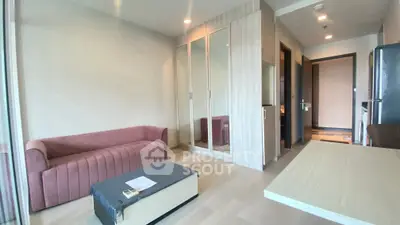 Modern living room with stylish furniture and mirrored wardrobe in a cozy apartment.