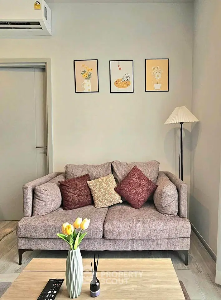 Cozy living room with stylish sofa, decorative pillows, and elegant wall art, perfect for relaxation.