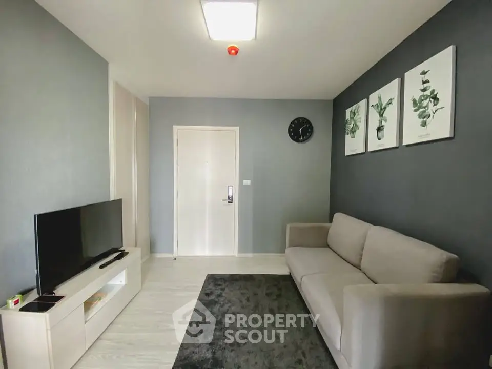 Modern living room with sleek sofa and wall-mounted TV in stylish apartment.